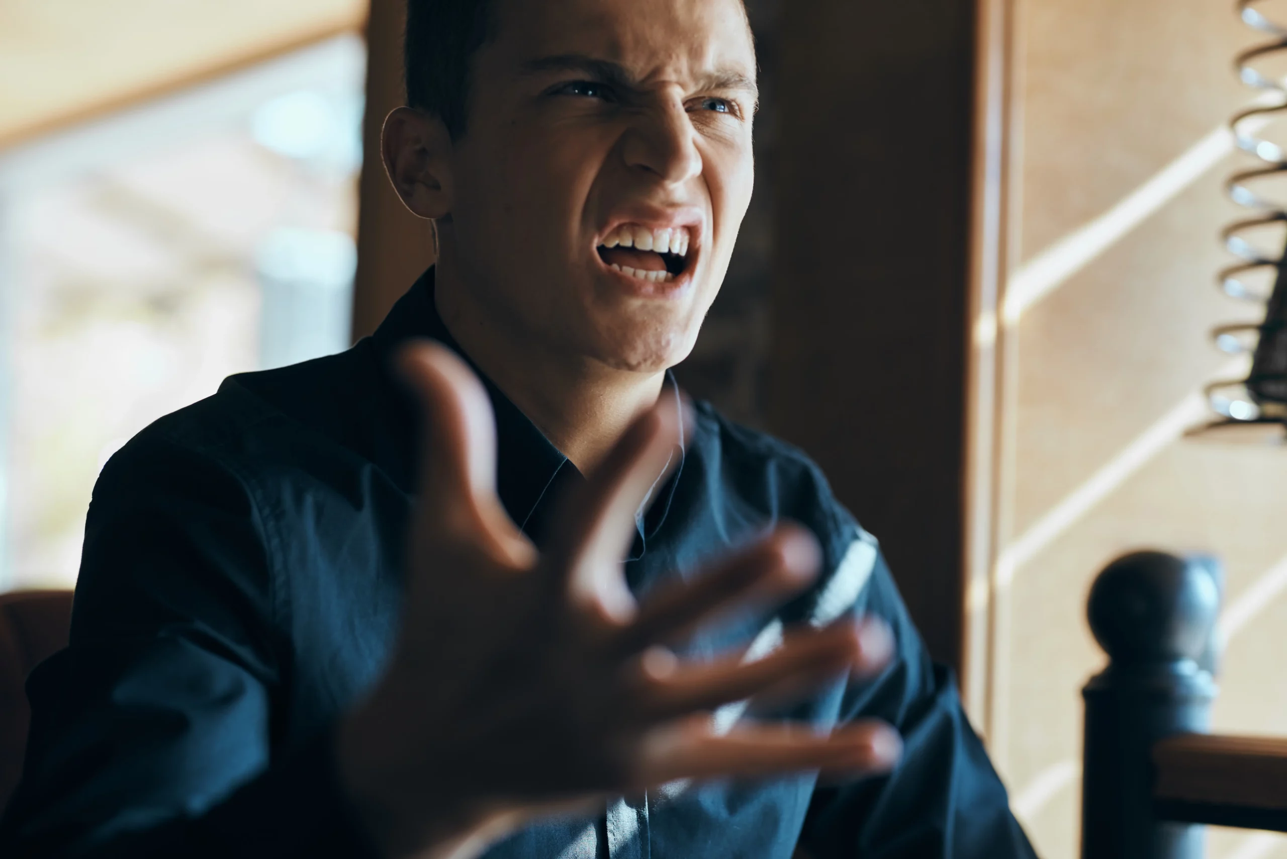 Frustrated young man gesturing angrily, illustrating legal issues in reducing murder charges to manslaughter defense.