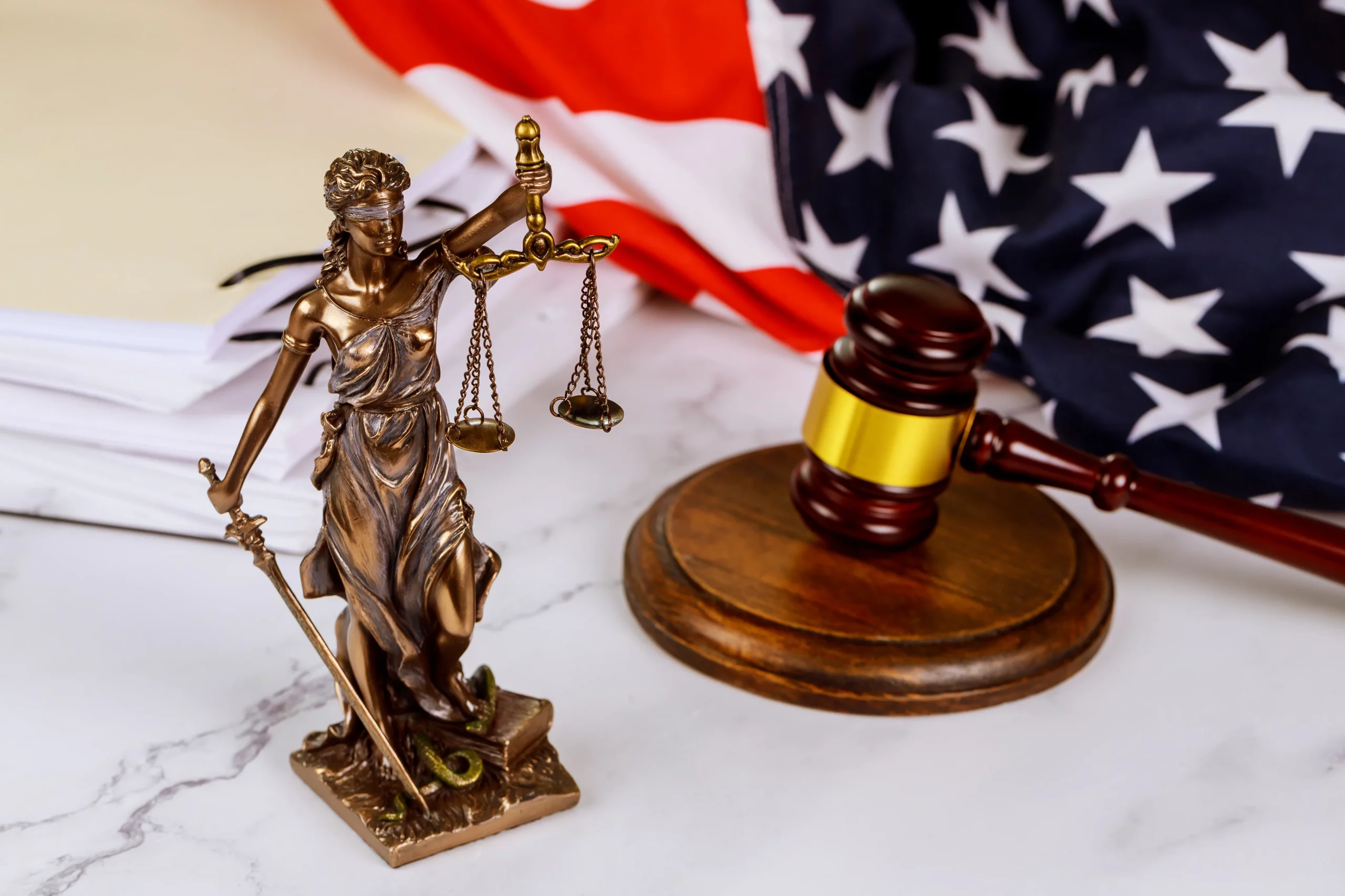 Lady Justice statue with scales and sword, gavel and American flag representing Indiana crimes, statute of limitations law, and legal defense