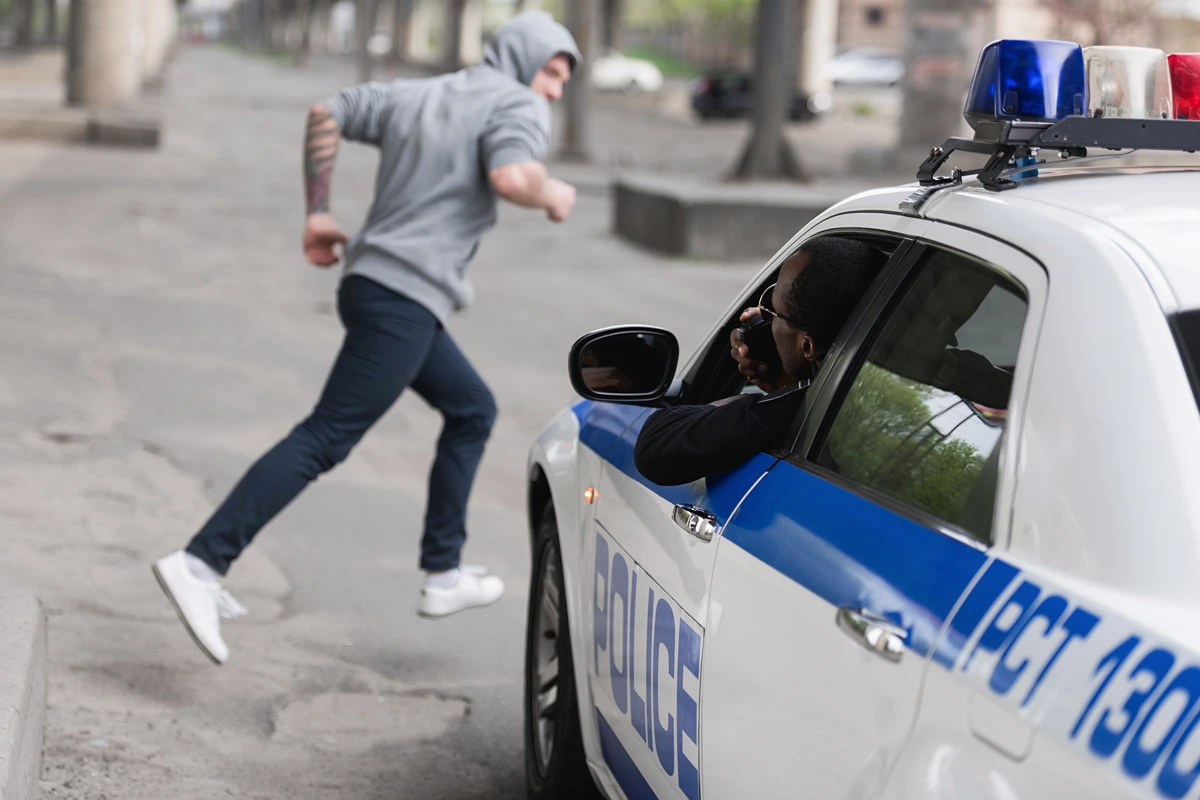 man runs from police officer in urban setting